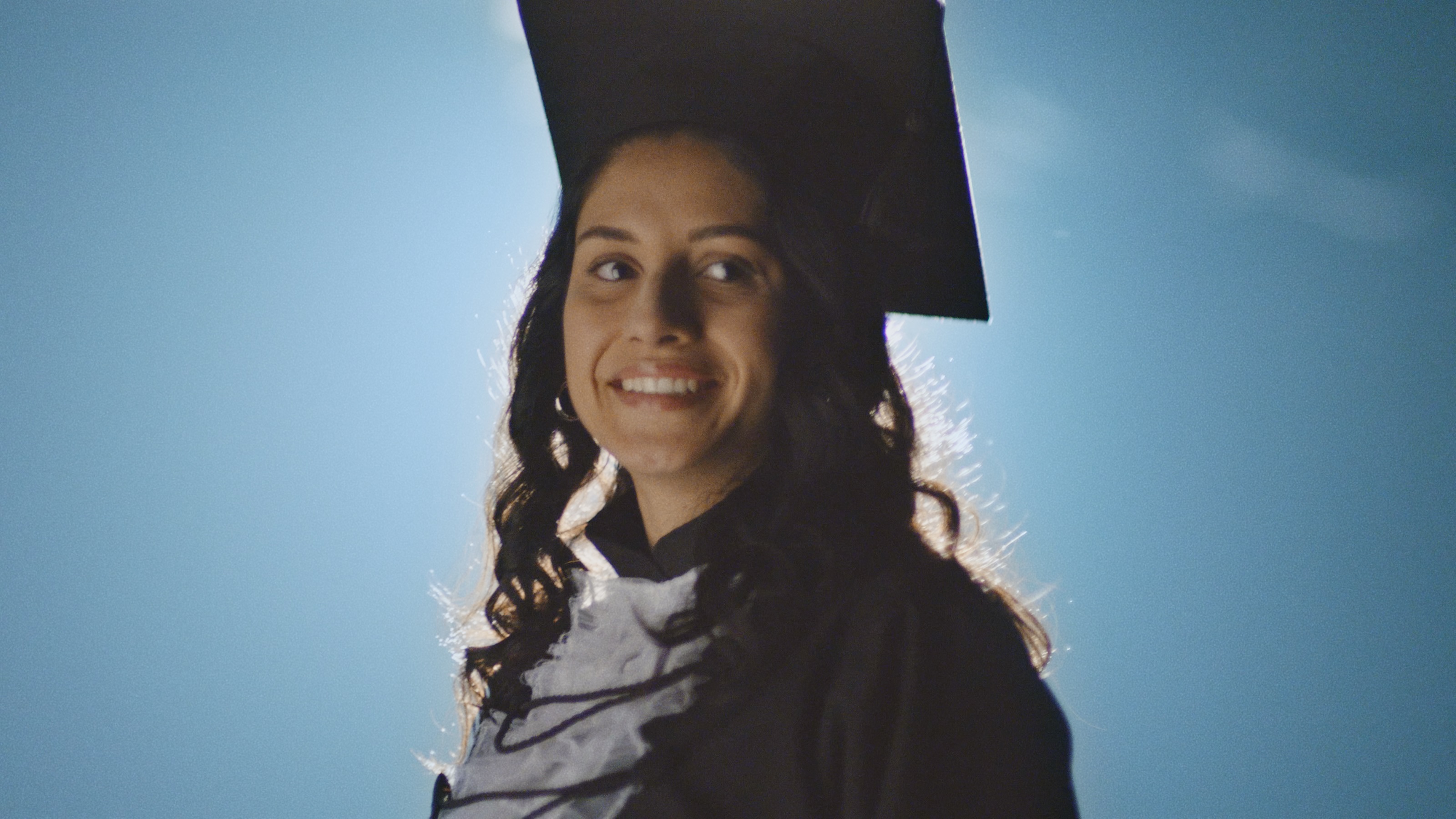 Uma estudante com roupa de formatura.