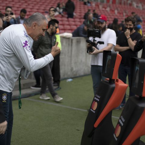 O técnico da seleção brasileira Tite cumprimenta os mascotes Mastercard.