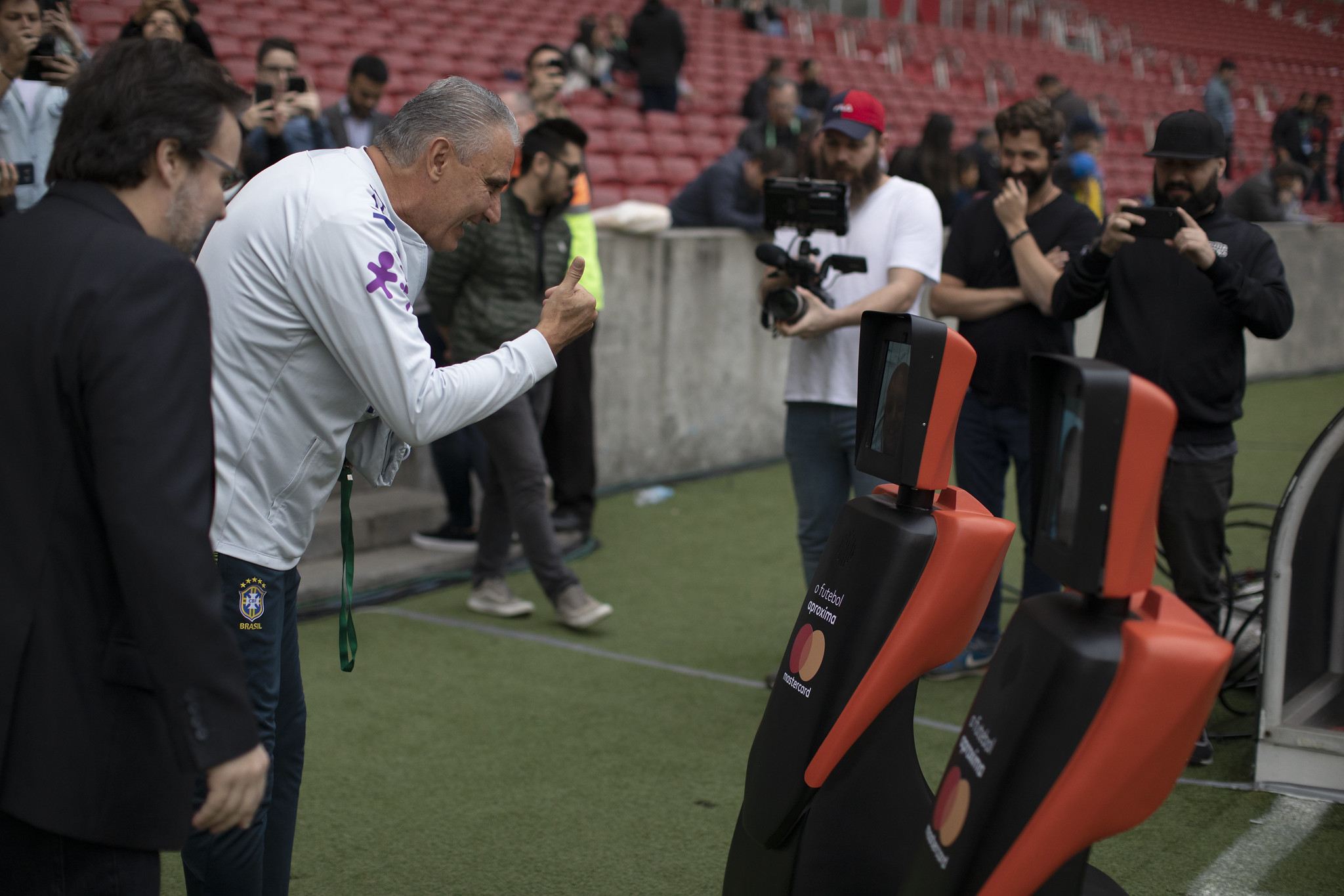 O técnico da seleção brasileira Tite cumprimenta os mascotes Mastercard.