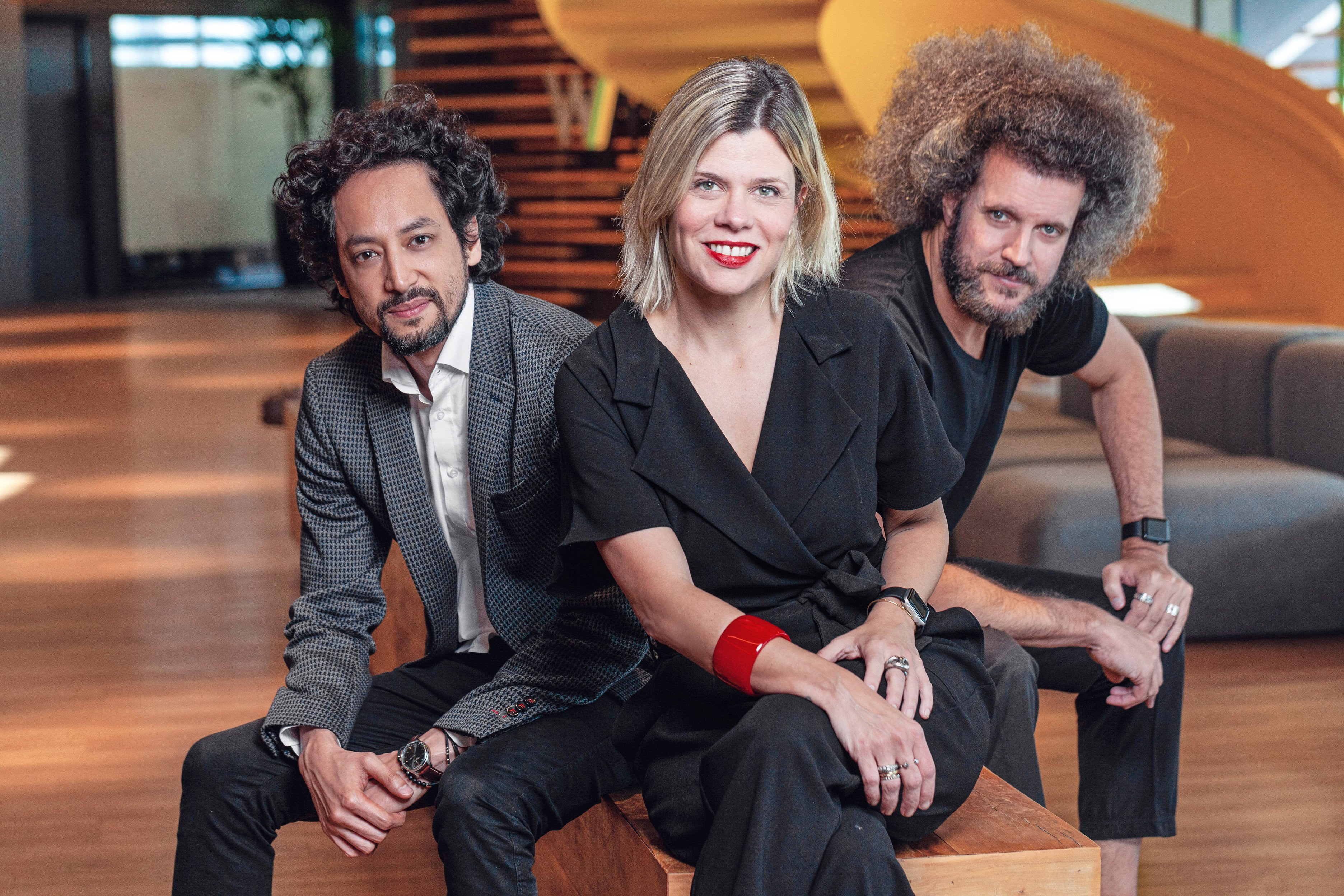 Kevin Zung, Renata Bokel e Hugo Rodrigues sentados juntos na recepção da WMcCann.