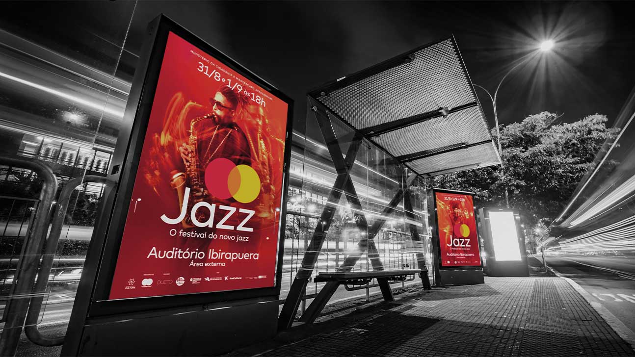 Na imagem, um ponto de ônibus é mostrado com mobiliário urbano exibindo as peças publicitárias de Mastercard Jazz.