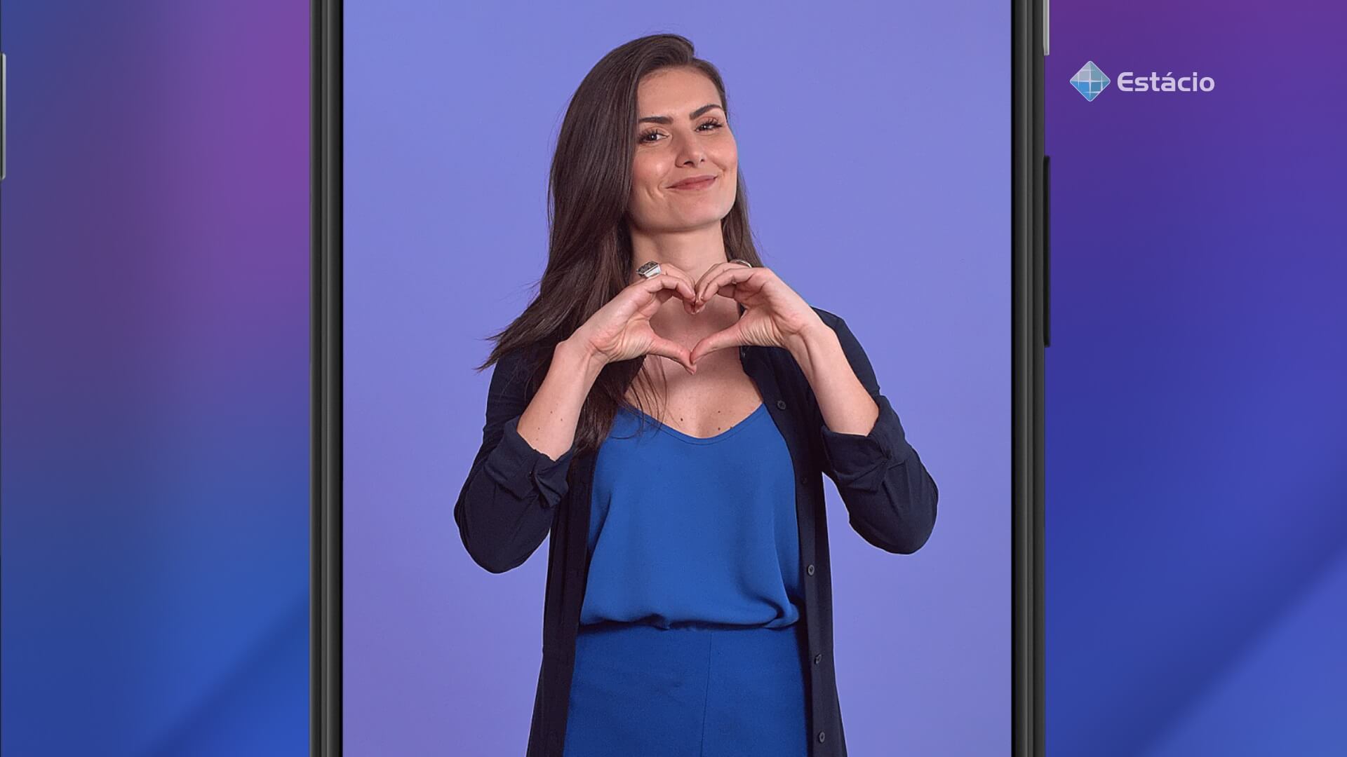 Foto da especialista em finanças, Nathalia Arcuri, fazendo o formato de um coração com as mãos, e o logo da Estácio no canto superior direito, tudo em fundo de cor azul.