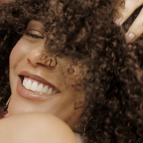A imagem foca na atriz Tais Araújo sorrindo.