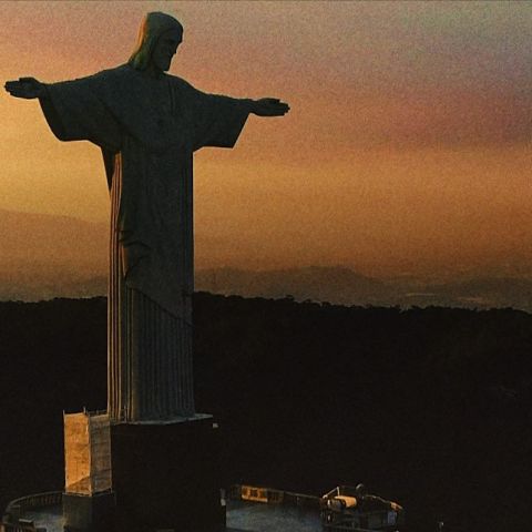 Na imagem, aparece a estátua do Cristo Redentor, e ao fundo o estádio do Maracanã.